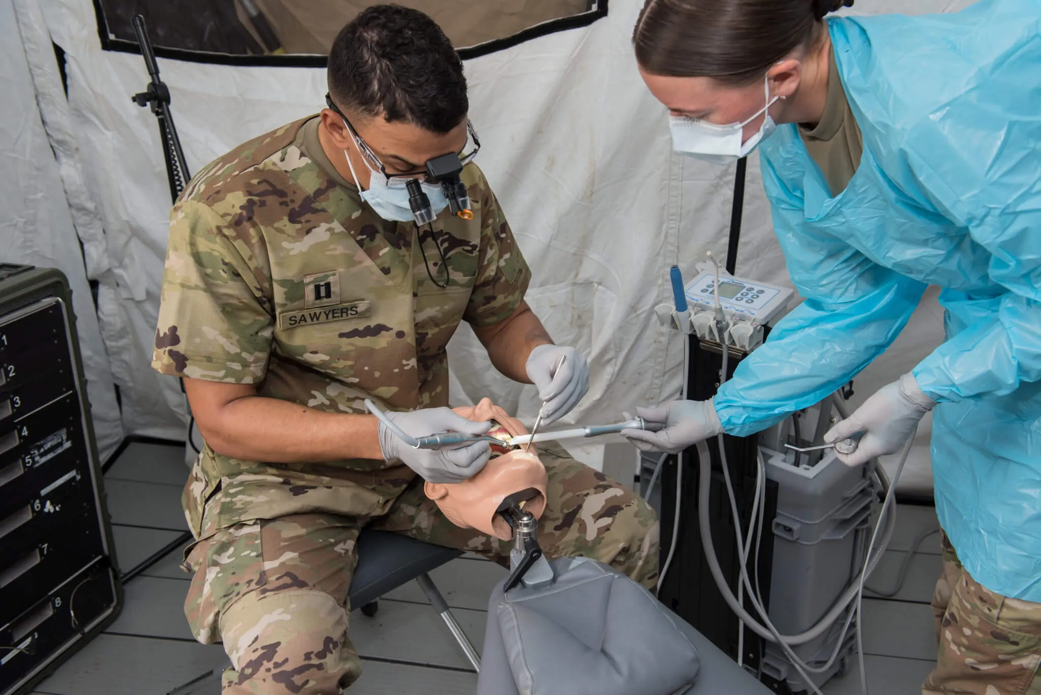 military dentist and assistant using aseptico products on a practice dummy